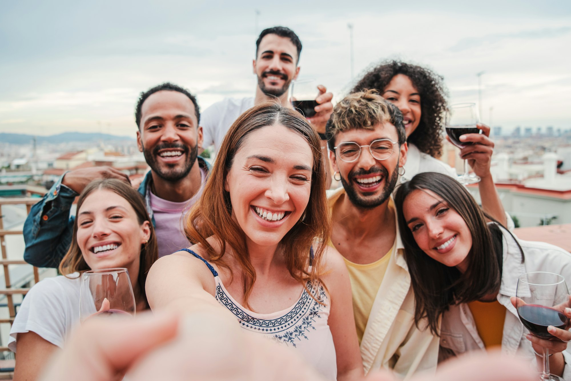 Big group of young adult multiracial friends taking a selfie portrait together for the social